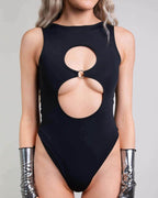 Matte black keyhole rave bodysuit with circular chest cutouts and O-ring detail, front view on model
