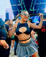 Woman in a stylish matte black keyhole top enjoying a rave, showcasing festival fashion and vibrant atmosphere.