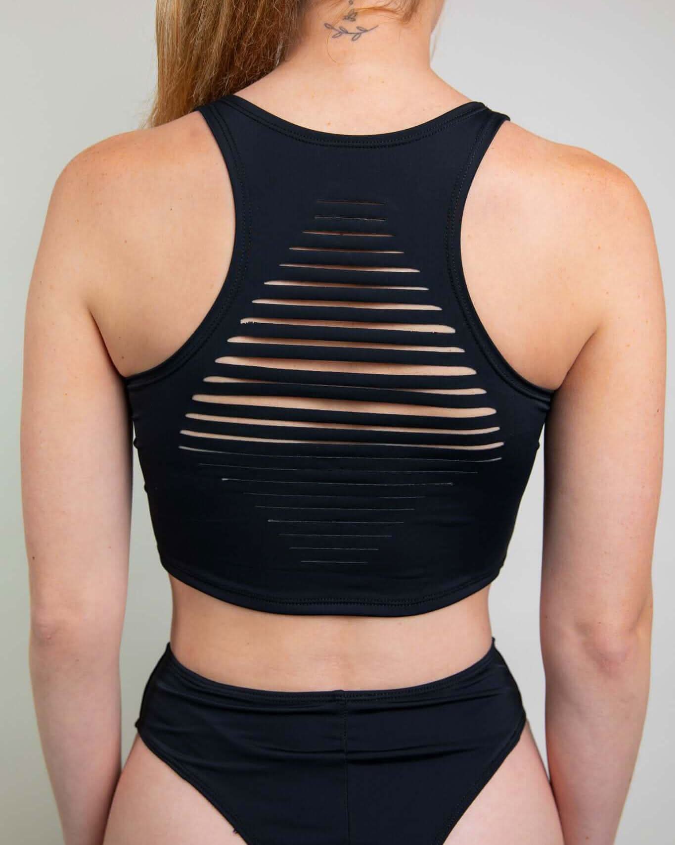 Back view of a black crop top featuring stylish slit design, ideal for rave outfits and comfortable movement.