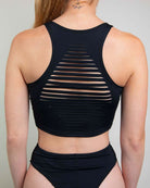 Back view of a black crop top featuring stylish slit design, ideal for rave outfits and comfortable movement.