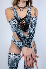 Model crossing arms while wearing Meltdown Arm Sleeves, highlighting their full length and vibrant trippy design.