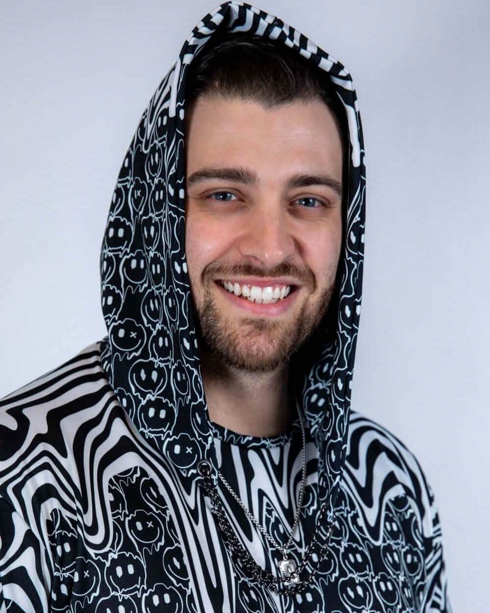 Close-up of the Meltdown Assassin Hood with the model smiling, highlighting the trippy pattern and snug hood fit.
