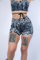 Back view of Meltdown High Waist Shorts, highlighting the flattering high-rise fit and bold trippy smiley pattern.