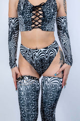 Model wearing the Meltdown High Waisted Thong with matching pieces, highlighting the high-rise waist and trippy smiley design.