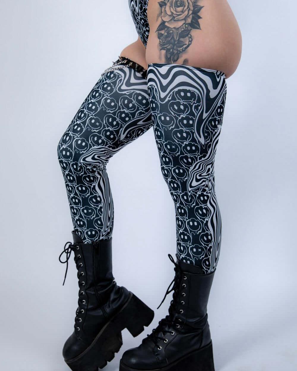 Model in Meltdown Leg Sleeves posing with one knee bent, showcasing the stretchy fit and bold festival-ready pattern.