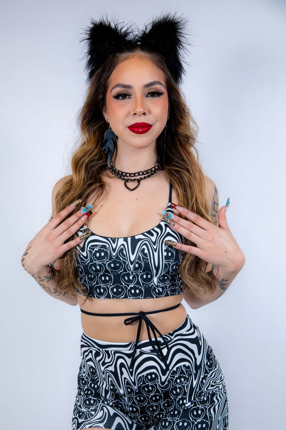 Model in the Meltdown Lush Top with arms crossed, emphasizing its sporty fit and rave-ready energy.