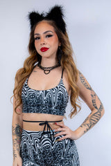 Front-facing view of the Meltdown Lush Top, featuring the bold melty smiley pattern and confident pose.