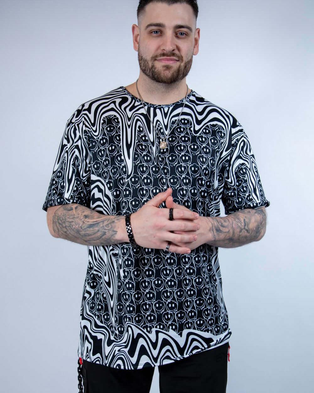 Model wearing the Meltdown Oversized Softee in a front-facing pose with hands clasped, showing off the relaxed fit and trippy smiley design.