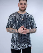 Male model wearing black white Meltdown oversized rave bodysuit style tee with trippy melting patterns festival outfit front view