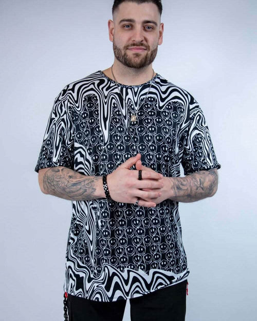 Male model wearing black white Meltdown oversized rave bodysuit style tee with trippy melting patterns festival outfit front view