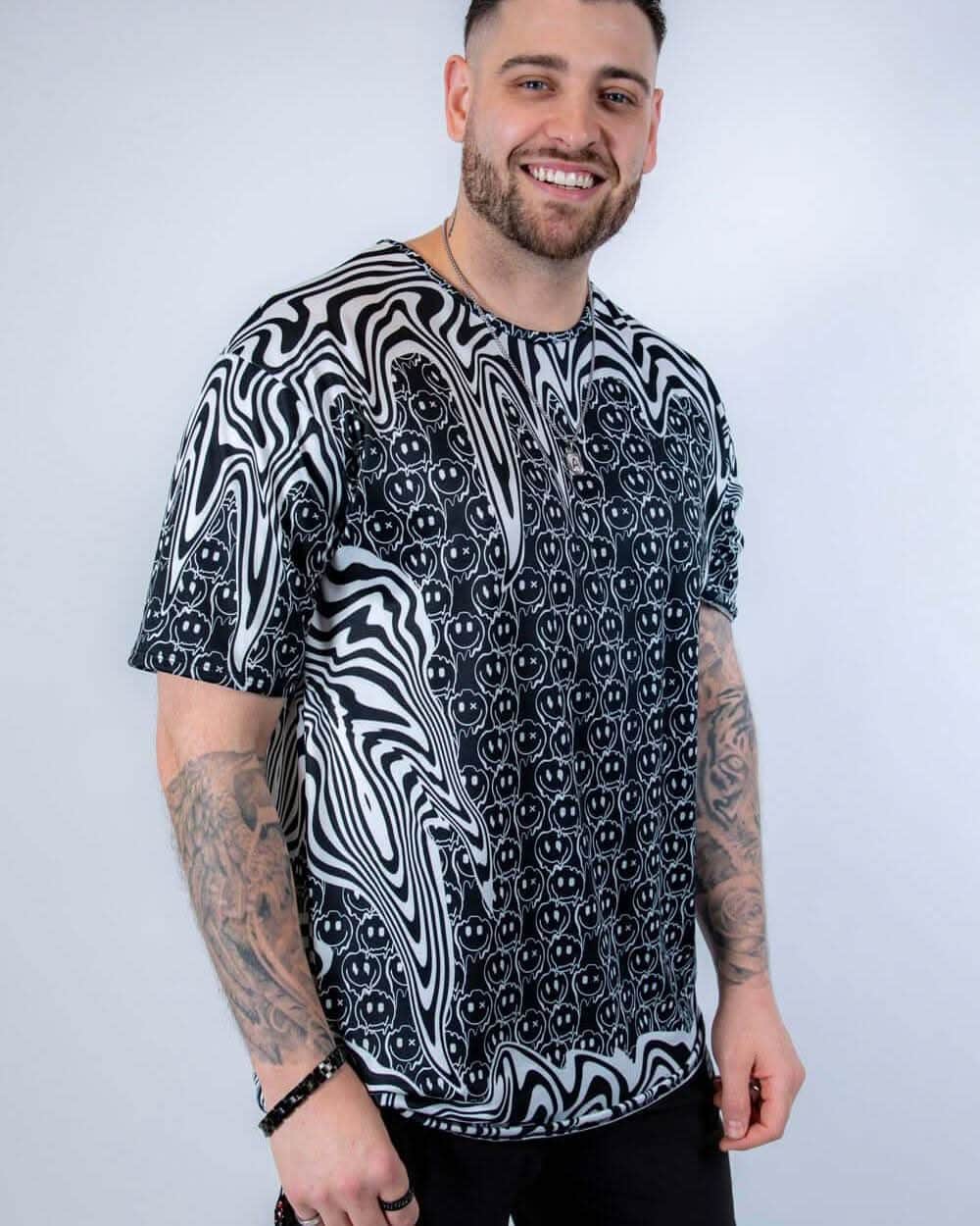 Male model wearing black white Meltdown oversized rave bodysuit style shirt festival outfit front view