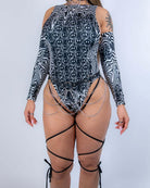 Back view of the Meltdown Sideboob Bodysuit, showing adjustable leg straps and cheeky coverage in the melty pattern.