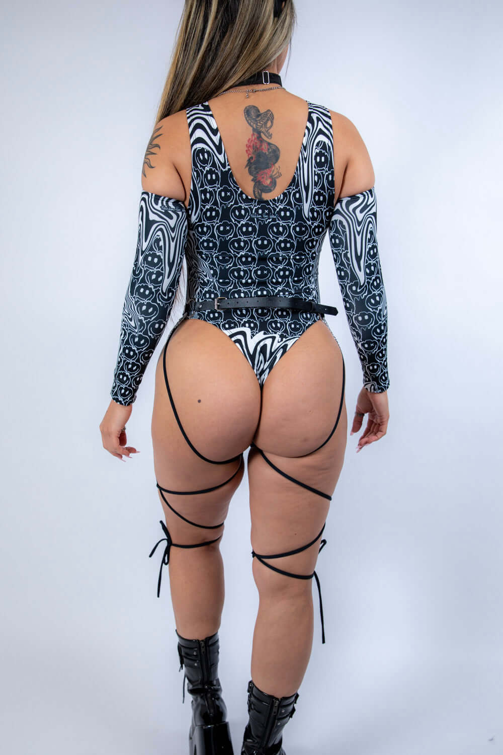 Rear view of the bodysuit with model standing tall, emphasizing strap details and full back design.