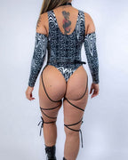 Back view of Meltdown rave bodysuit with sideboob cutouts and leg straps in black white psychedelic print