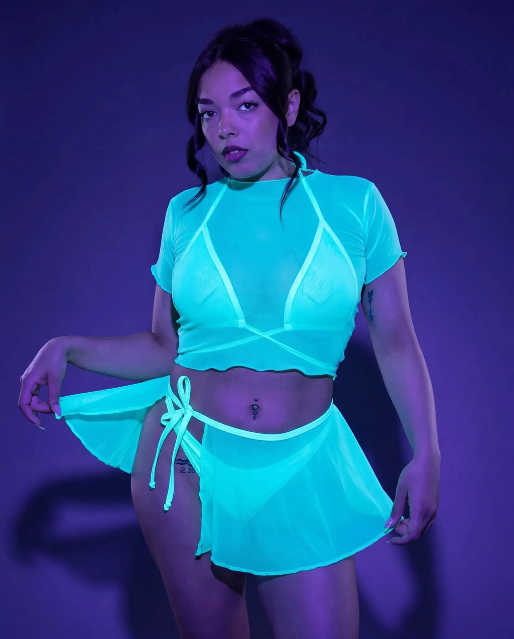 Model wearing mint mesh swirl rave skirt and crop top set in outdoor festival setting — white