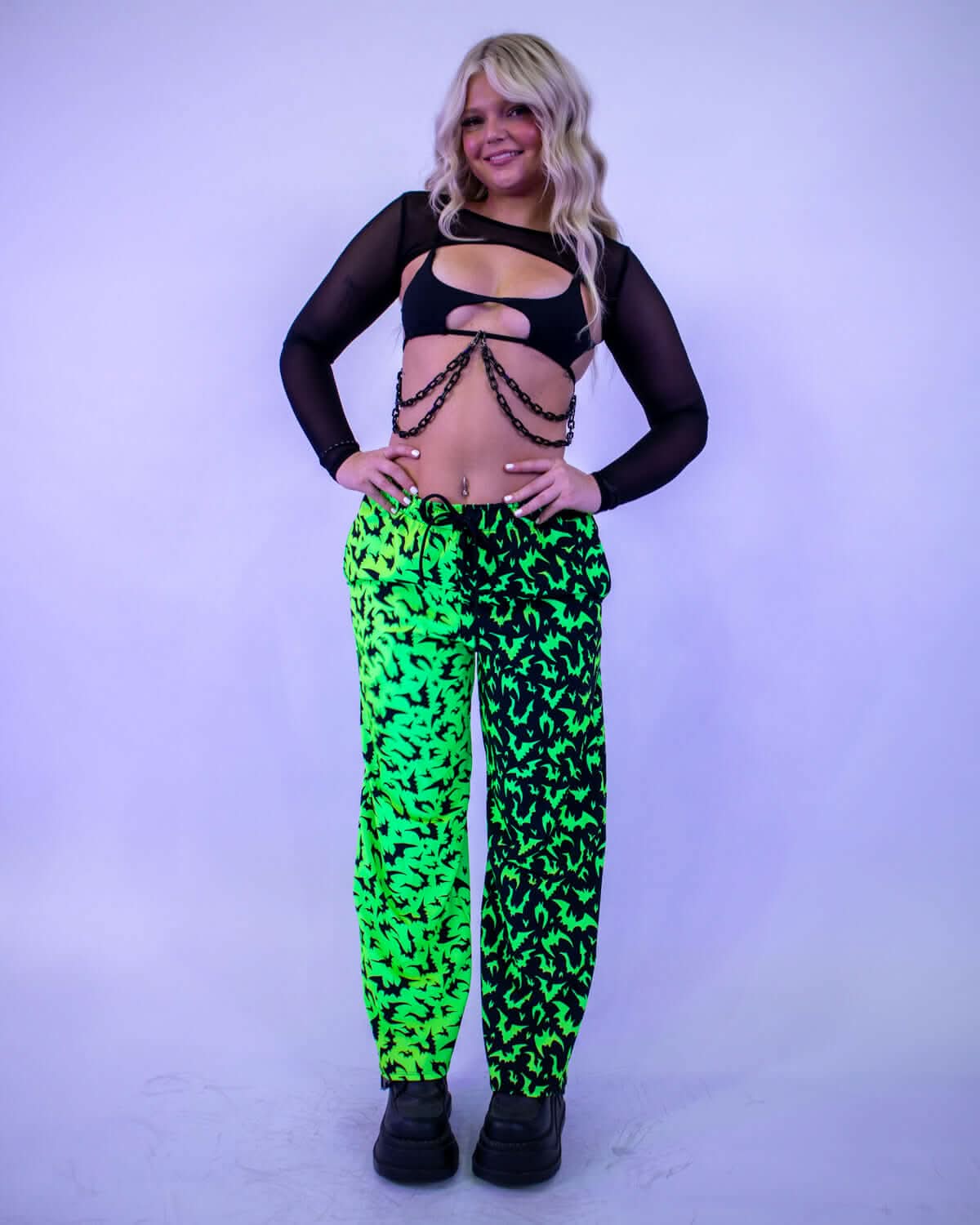 OG Batty 50/50 Lucy Pants - UV Green worn by model, showcasing neon lime and black bat print, perfect for rave outfits.