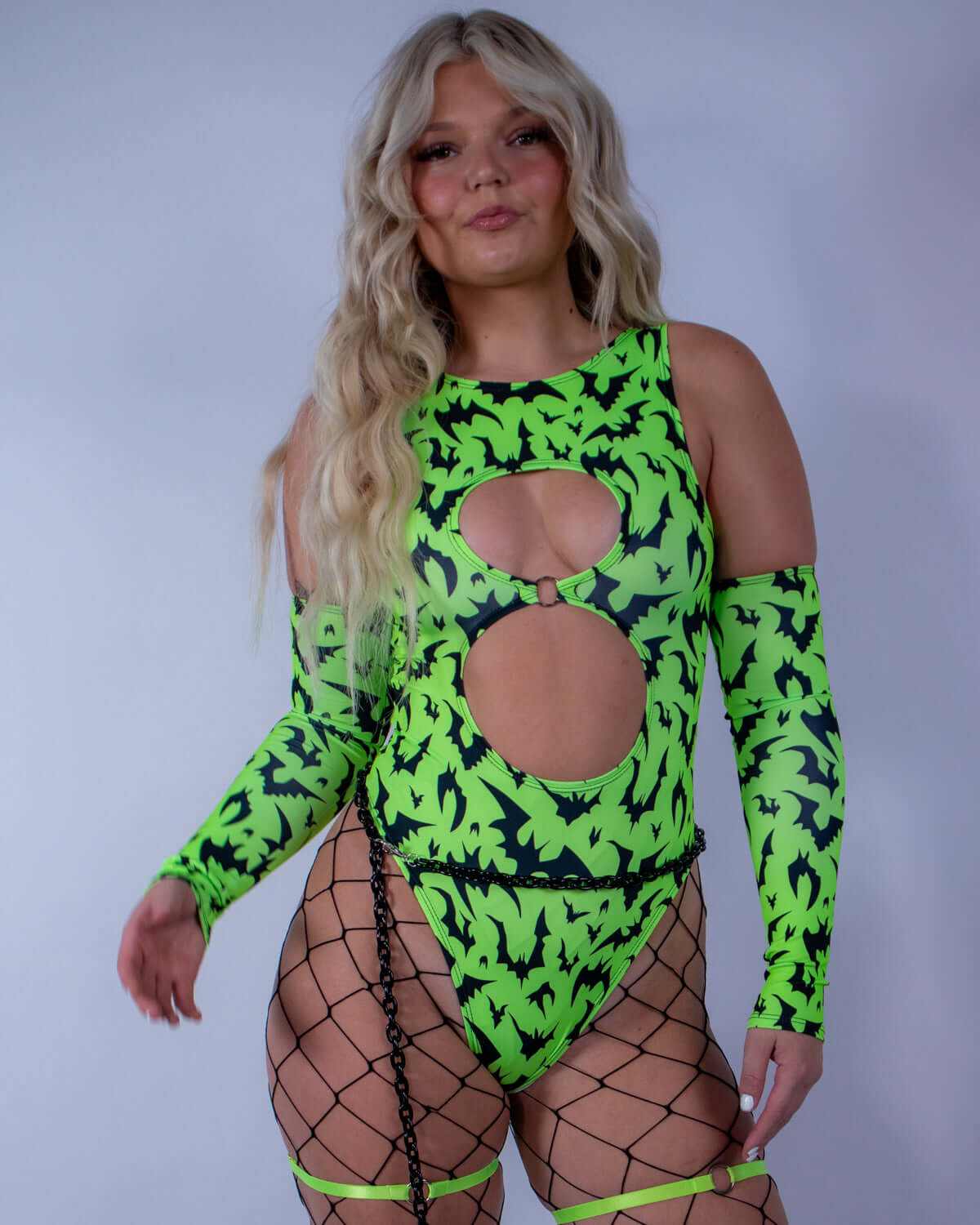 Model wearing OG Batty Arm Sleeves - UV Green with bat print, perfect for rave outfits and dance parties.