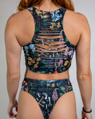 Poison Slit Crop Top showcasing edgy slit details and vibrant floral print, perfect for rave outfits.
