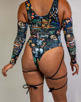 Poison Slit Sideboob Bodysuit with leg straps, featuring a vibrant skull and floral print, perfect for rave outfits.