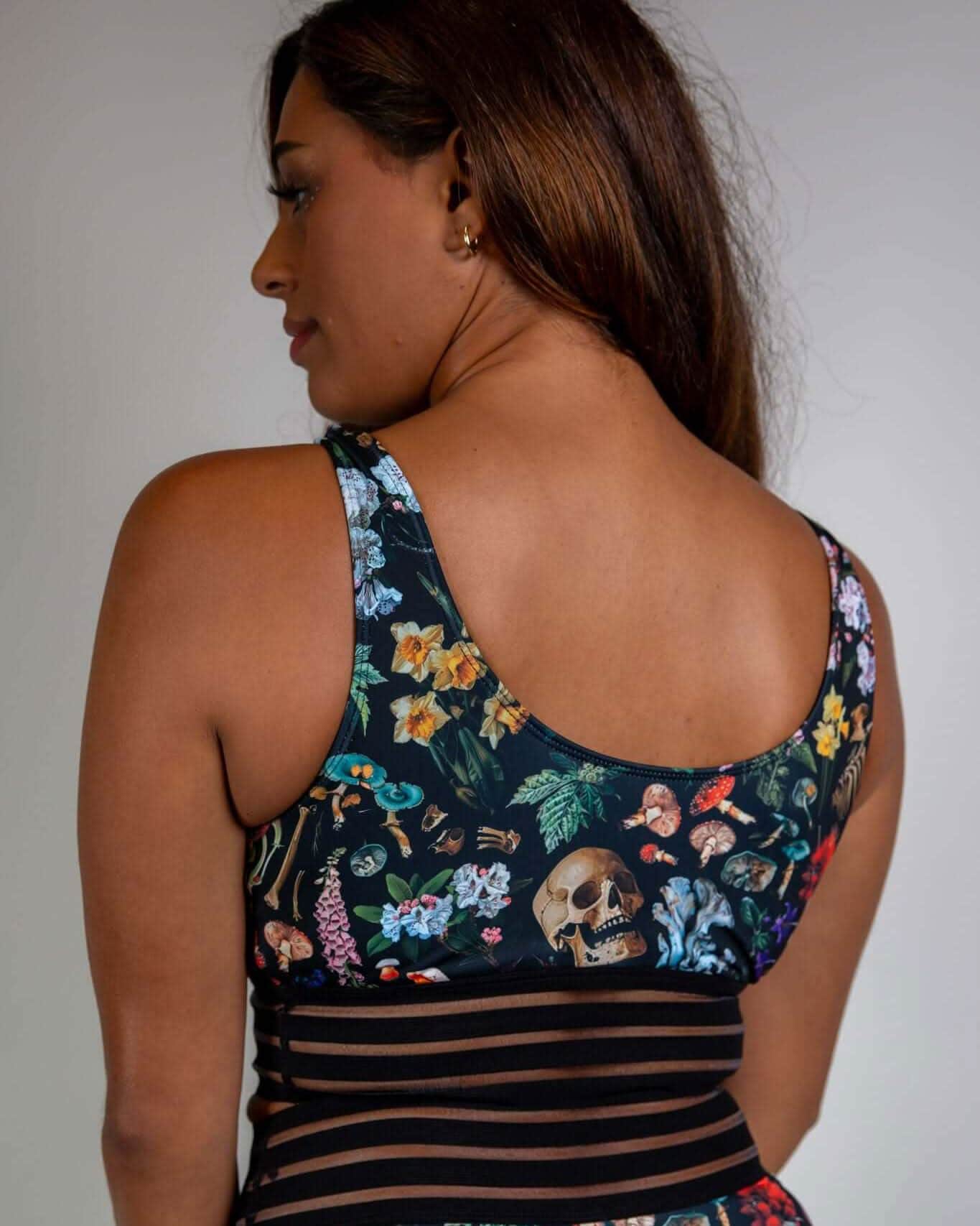 Model showcasing the Poison Sporty Top with bold skull and mushroom print, featuring supportive fit and breathable mesh.
