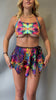 Video of Freedom Rave Wear set featuring a psychedelic lush top with unique cutouts and a matching flowy skirt. Perfect for vibrant festival looks