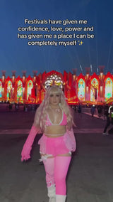 rave girl in neon pink and white rave outfit and matching accessories dances in front of main stage and edc las vegas music festival