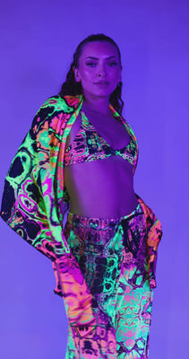 Model wearing vibrant neon rave outfit featuring a matching bikini and cover-up, perfect for festivals.