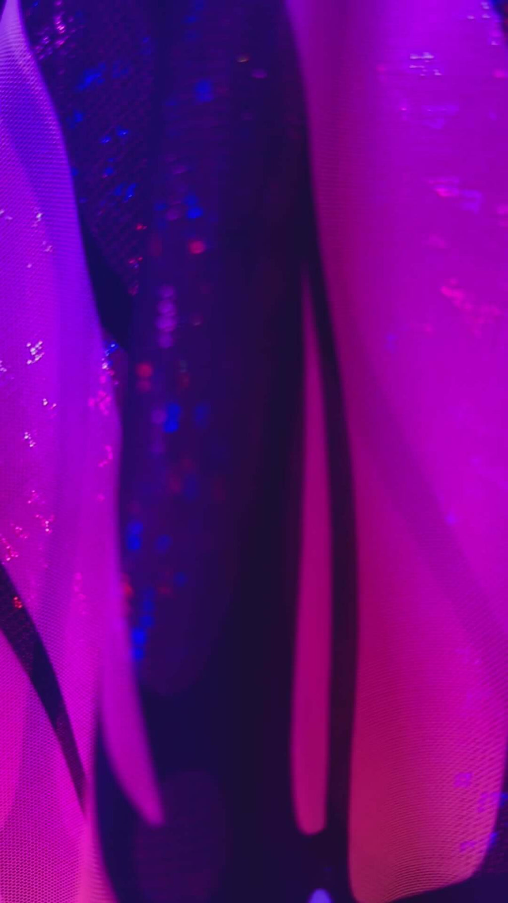 Close-up of vibrant purple and black fabric showcasing a UV reactive design, perfect for rave outfits and clothing.