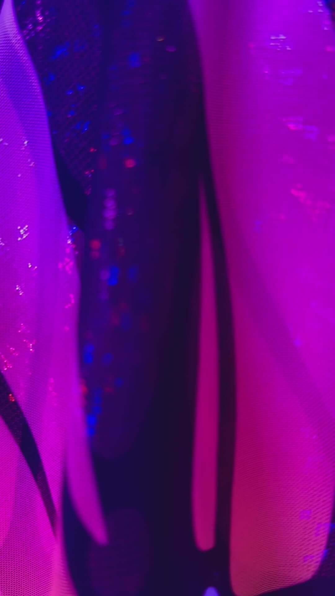 Close-up of vibrant purple and black fabric showcasing a UV reactive design, perfect for rave outfits and clothing.