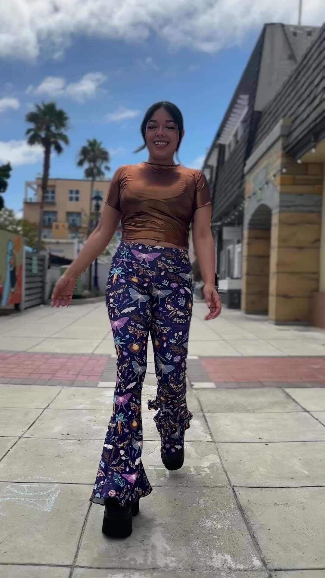 Model wearing Lucent Bell Bottoms, showcasing vibrant bioluminescent print, ideal for rave outfits.