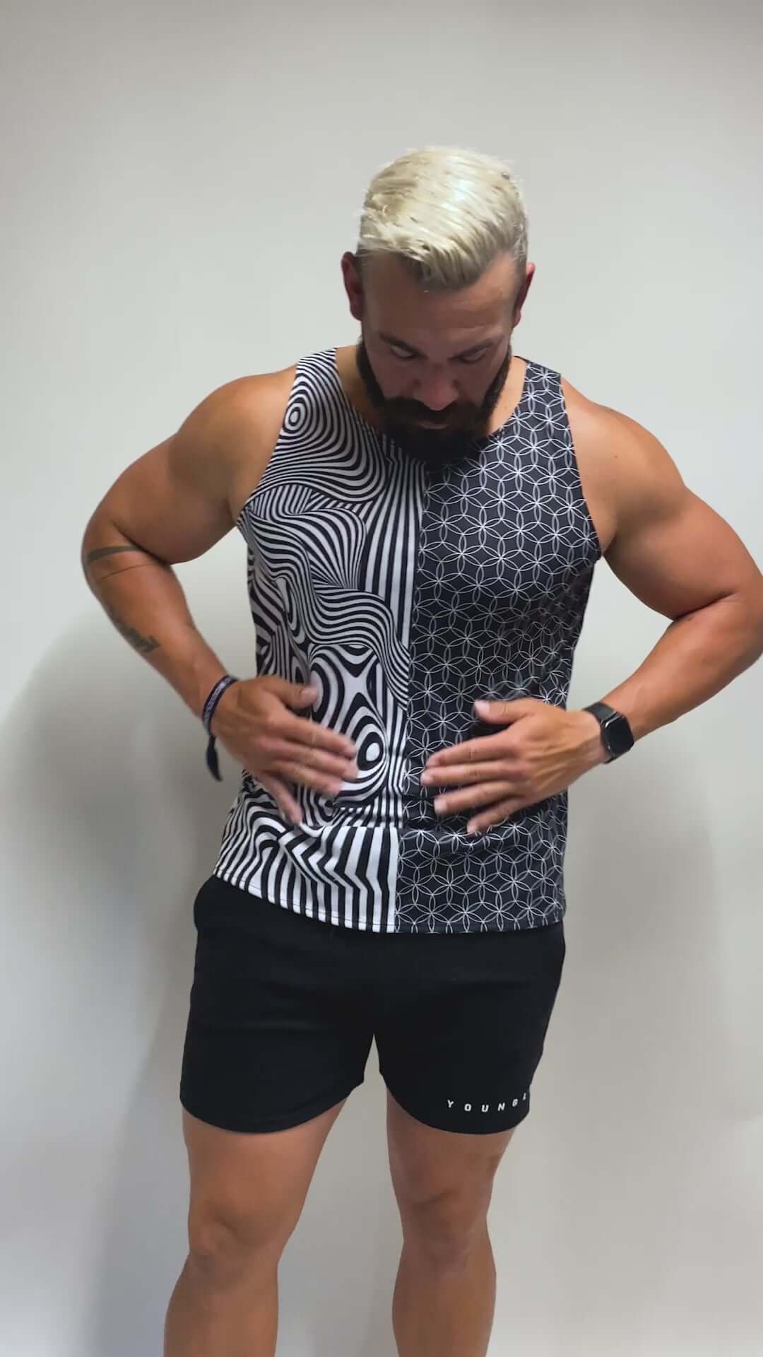 Model in a monochrome, geometric tank top with bold patterns, ideal for raves. Freedom Rave Wear offers unique festival fashion.