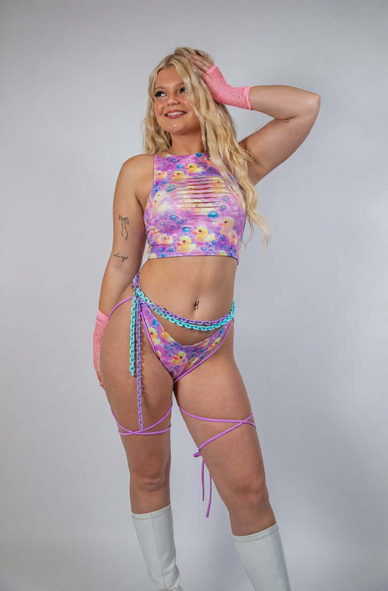 Model showcasing the Duckies Slit Crop Top, perfect for rave outfits, featuring a vibrant purple, yellow, and pink design.