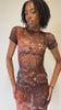 Model in a sheer brown patterned dress from Freedom Rave Wear, perfect for raves.