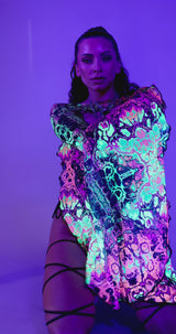 Model showcasing Intensity Mesh Bell Sleeves under UV light, emphasizing vibrant colors perfect for rave outfits.