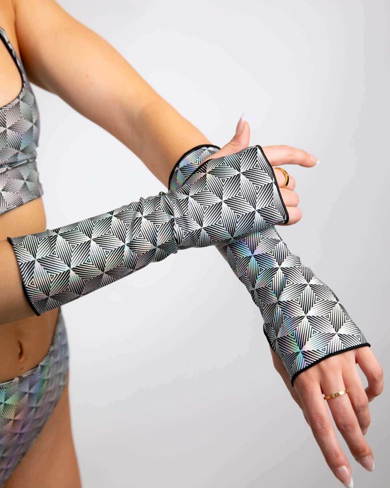 Model wearing Prism rave arm sleeves with holographic geometric pattern in crossed pose front view