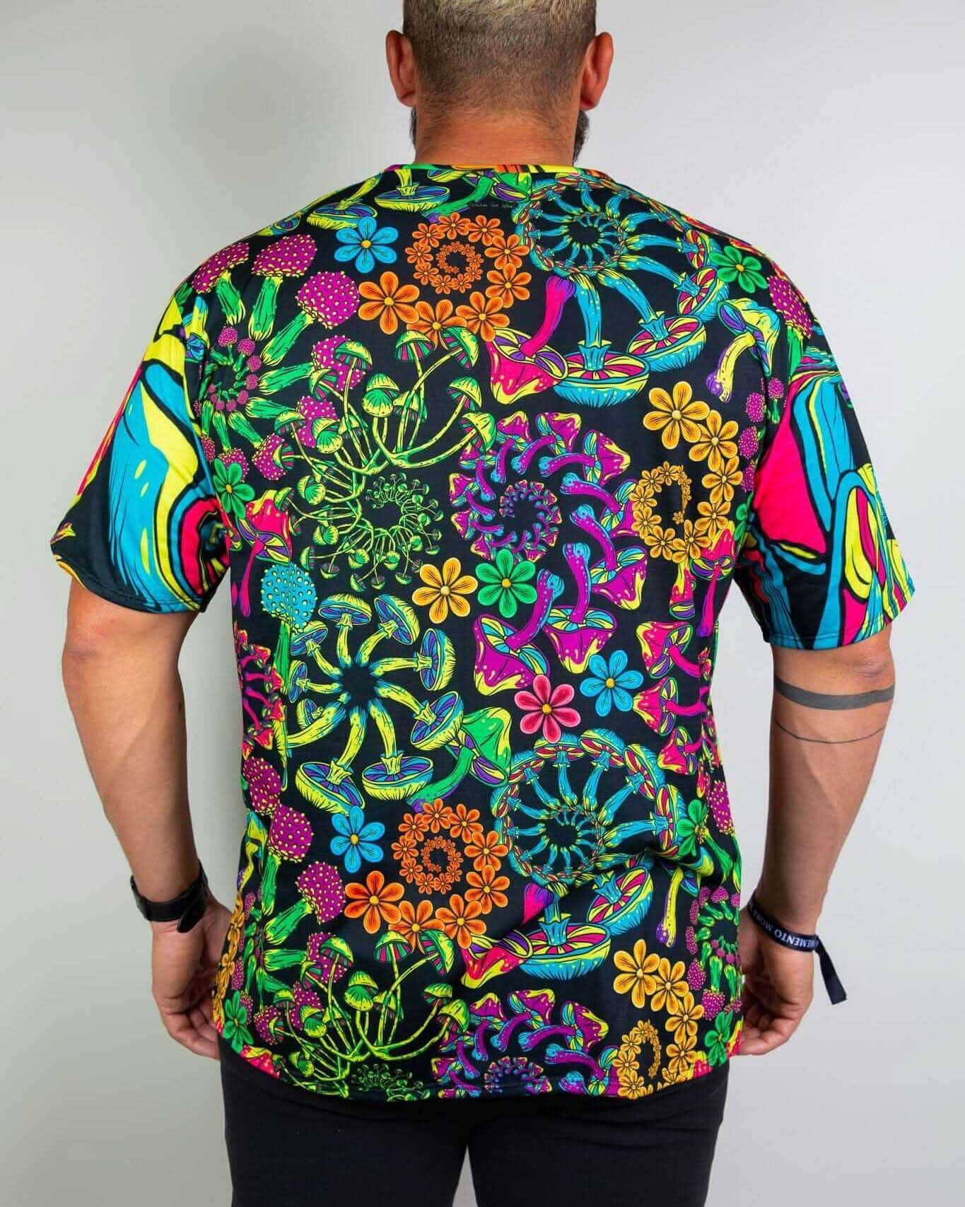 Back view of a man wearing the PsyBloom Oversized Tee with colorful mushroom and floral print, ideal for rave outfits.
