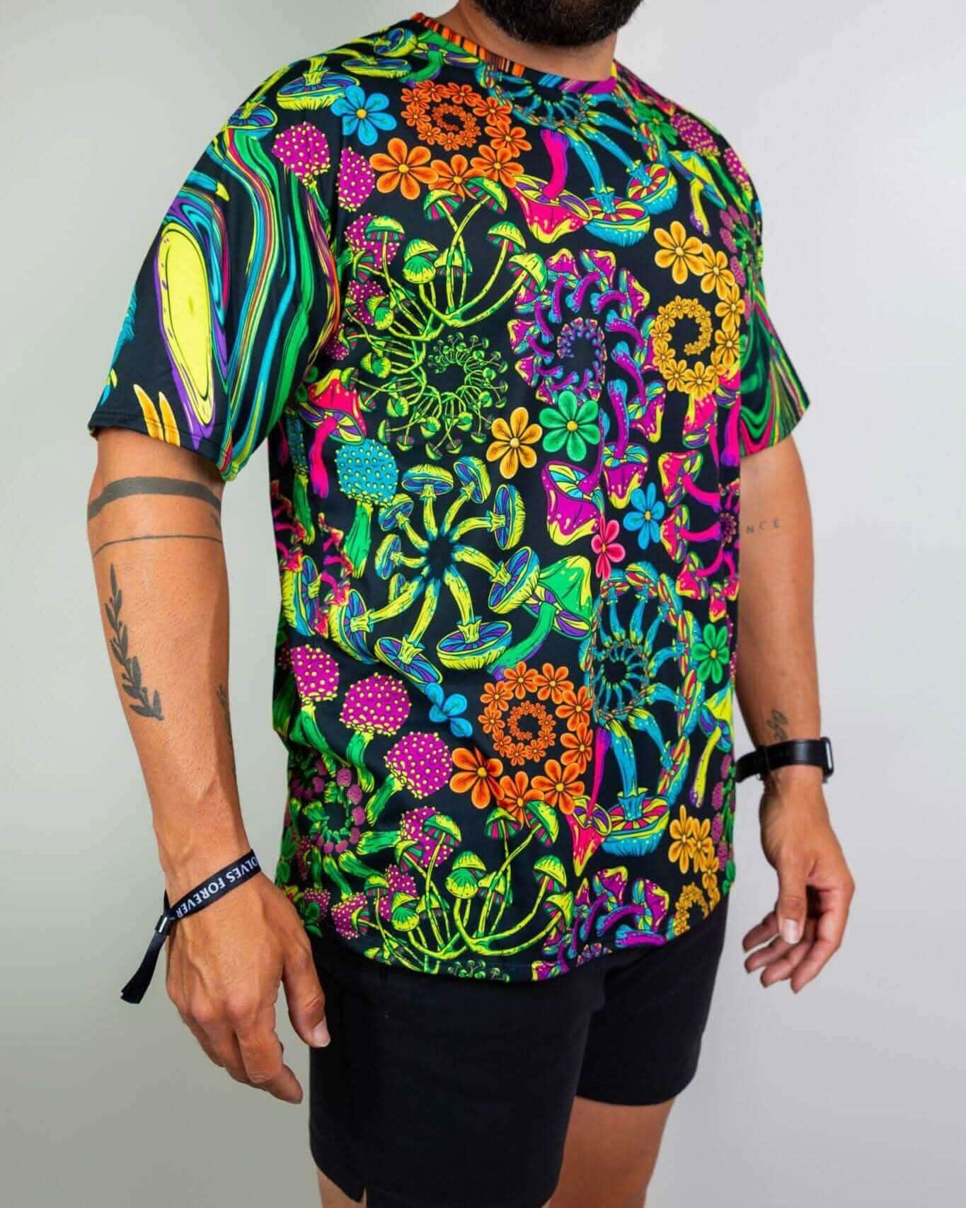 Man in vibrant PsyBloom Oversized Tee featuring a colorful mushroom and flower print, perfect for rave outfits.