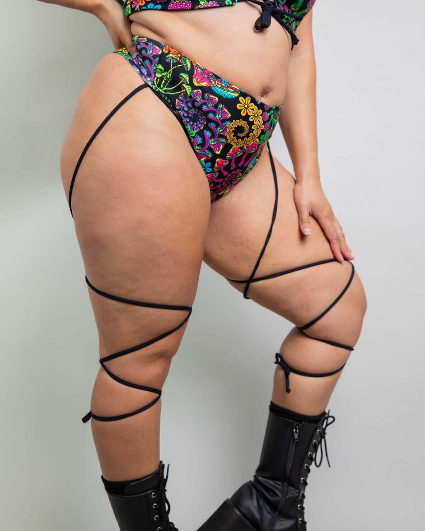 Model in colorful PsyBloom Strappy High Waisted Thong and lace-up boots, showcasing a vibrant rave outfit.