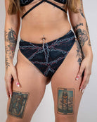 Model showcasing the Purgatory High Waisted Thong with a bold chain graphic, perfect for rave outfits.