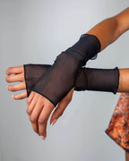Black mesh rave arm sleeves with thumb holes modeled on hands showing fingerless glove design