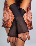 Black mesh rave arm sleeves with thumbholes modeled on hands showing festival wear styling