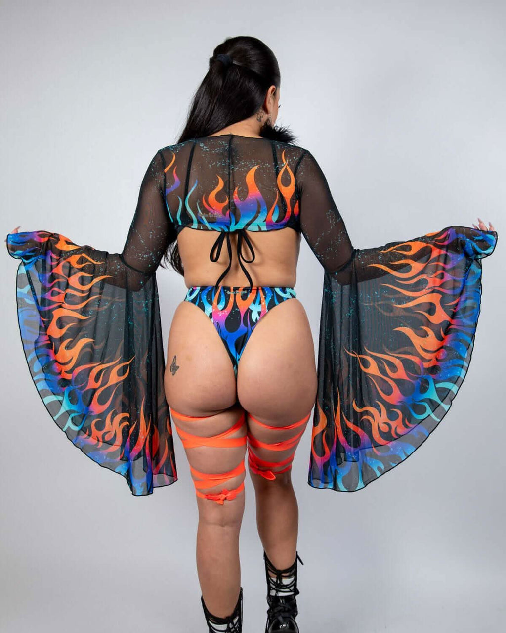 Rave arm sleeves in Blaze flame pattern shown from back with model's arms spread displaying bell sleeve silhouette