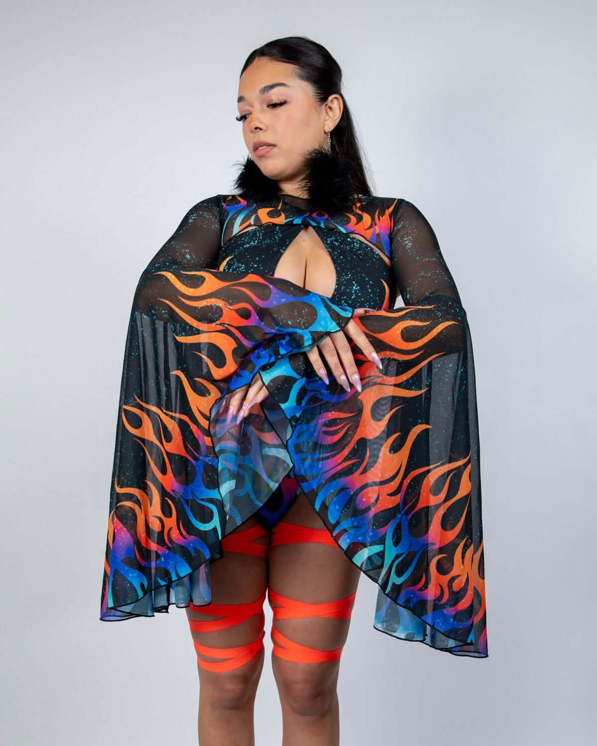 Model wearing Blaze flame print rave arm sleeves with bell design and red leg wraps for festival outfit