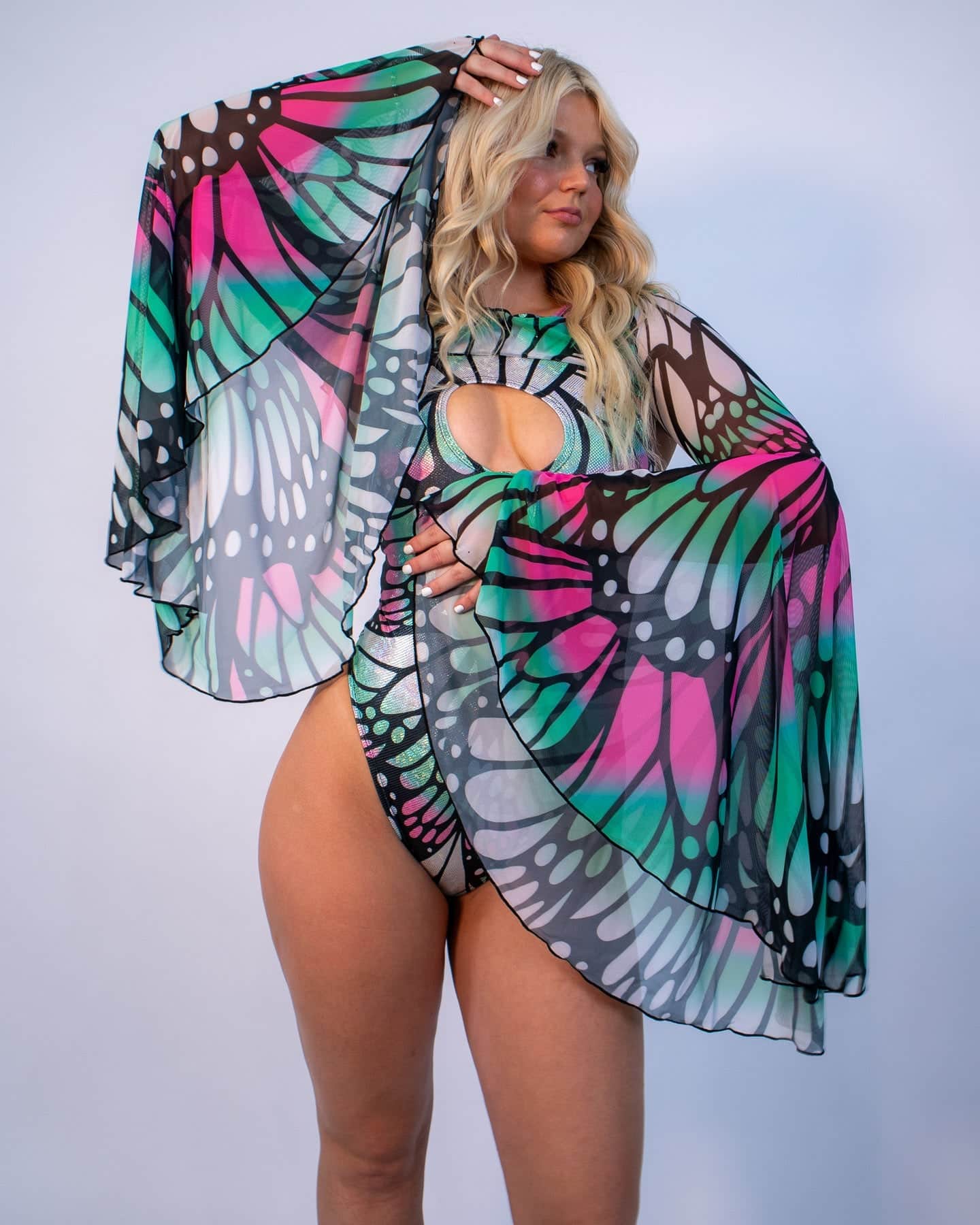 Model wearing colorful butterfly print rave arm sleeves with flowing bell design for festival outfits