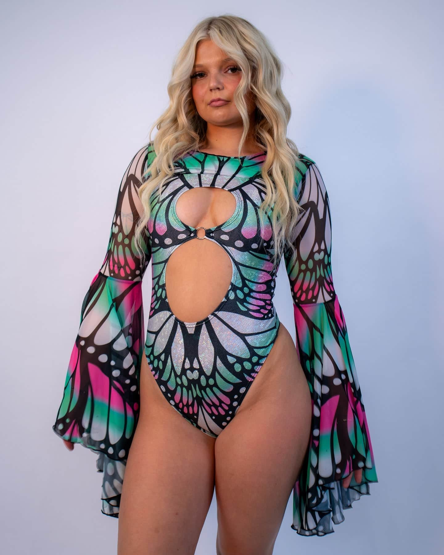 Rave arm sleeves with butterfly wing print in pink and teal, dramatic bell sleeves on model front view