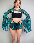Faewood mesh rave arm sleeves in teal green with dramatic bell flare, modeled with black festival outfit