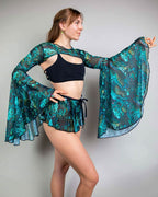 Faewood mesh rave arm sleeves in teal and turquoise worn by model in side pose showing dramatic bell sleeves