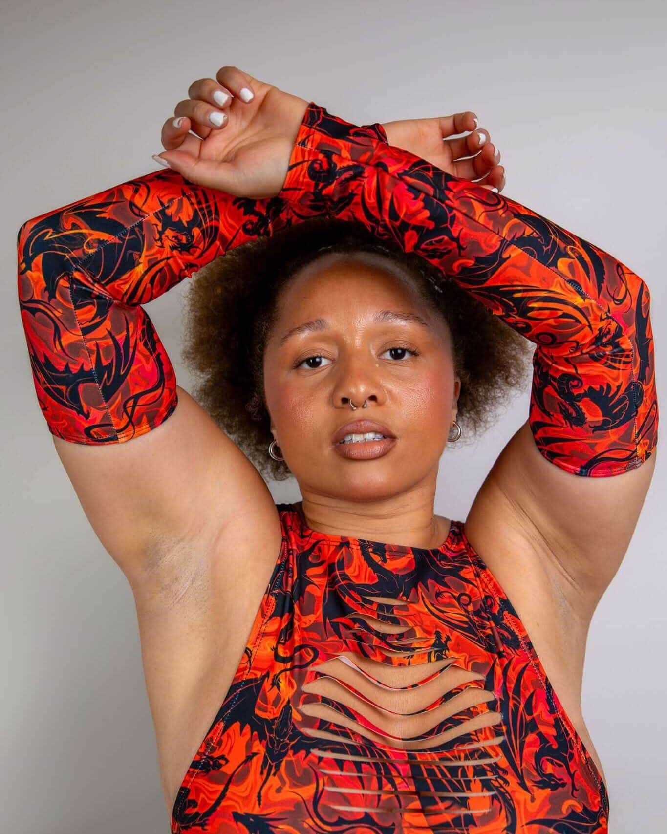 Forbidden dragon print rave arm sleeves with strategic slits modeled in artistic pose for festival fashion