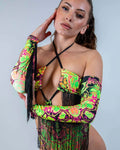 Model wearing Intensity rave arm sleeves with black fringe in neon psychedelic pattern for festival outfit