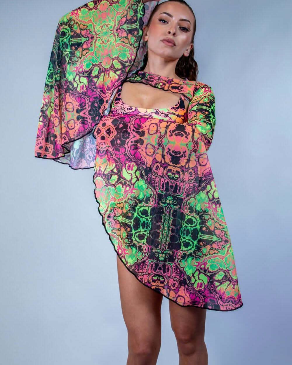Model wearing Intensity psychedelic rave arm sleeves with neon green pink pattern in festival outfit front view